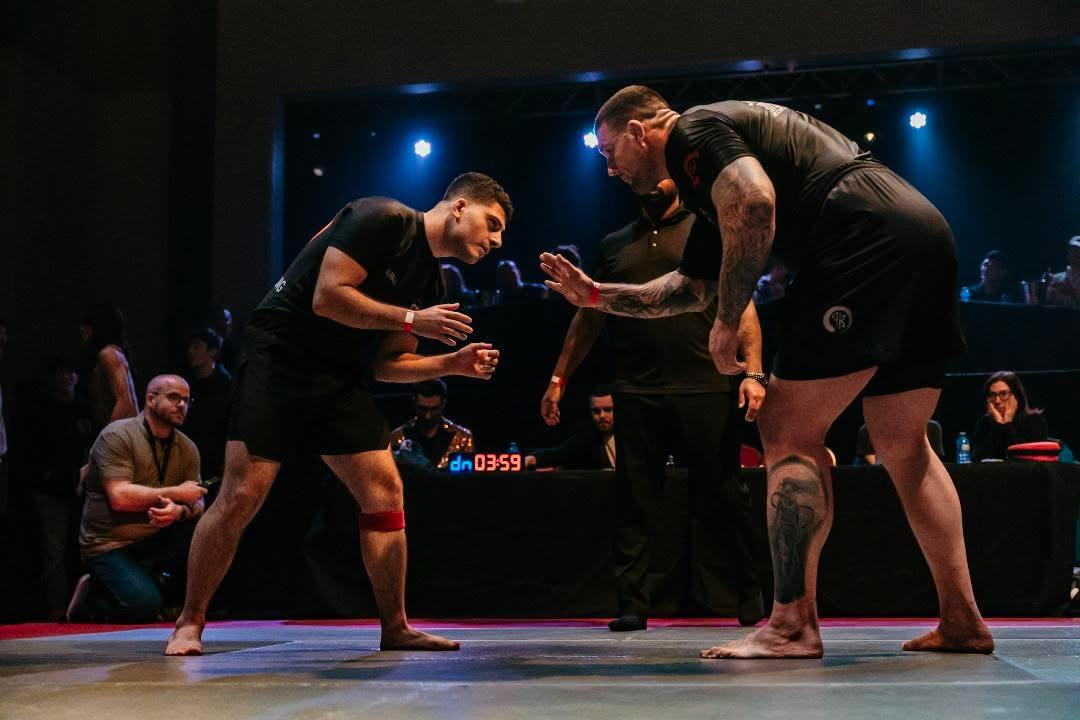 Two competitors and a referee before a submission grappling match